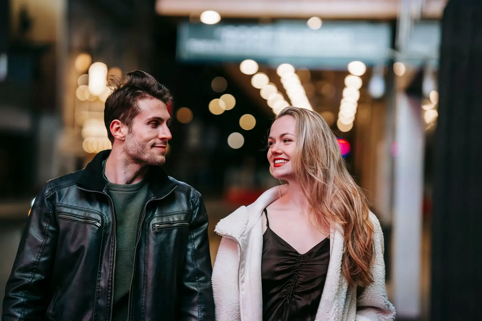 A couple walking through a city at night